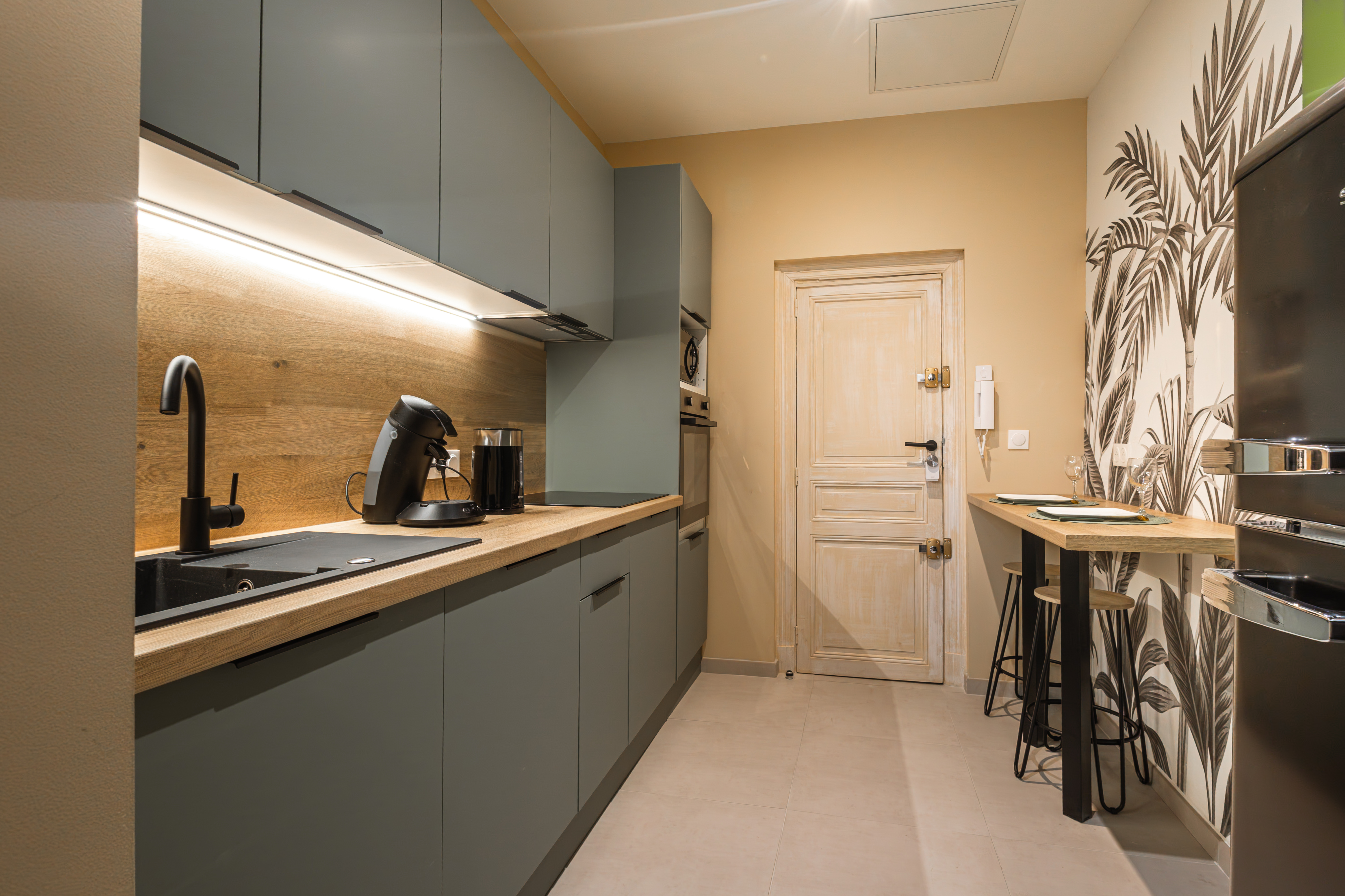 Cuisine vert sapin livrée, papier peint tropical et coin bar