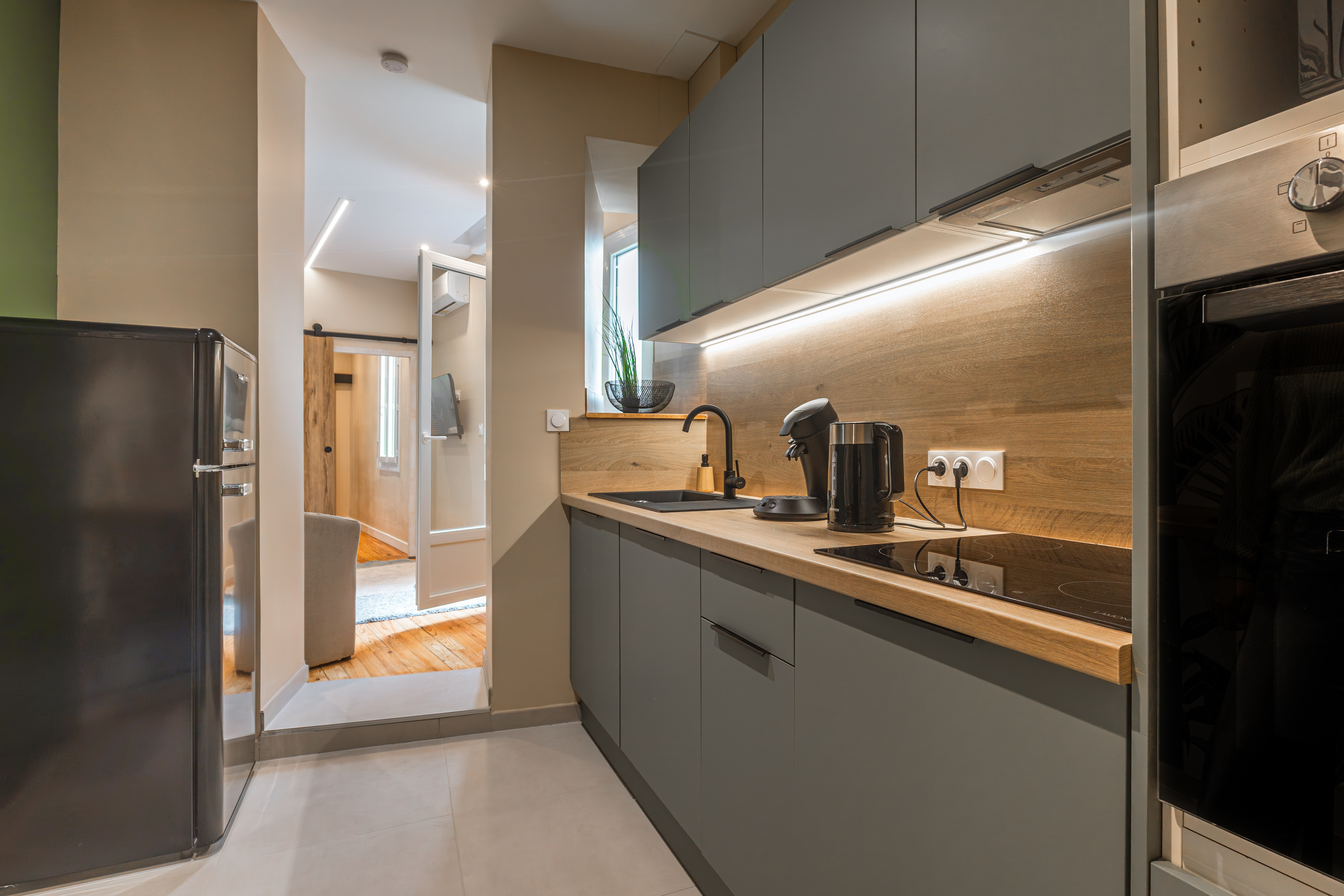 Cuisine vue depuis porte d'entrée, enfilade vers couloir