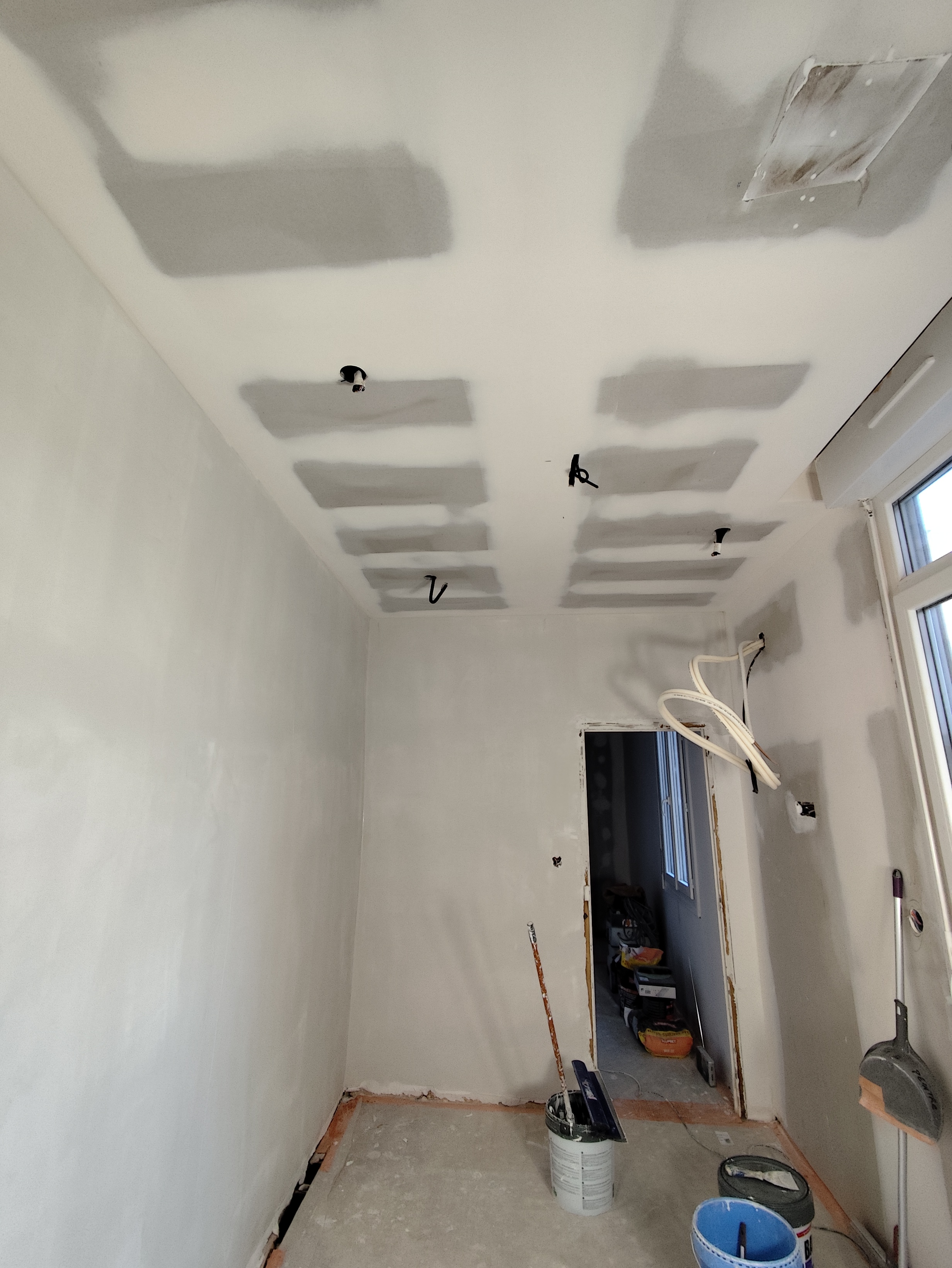 Salon brut, câblages apparents et mur à doubler